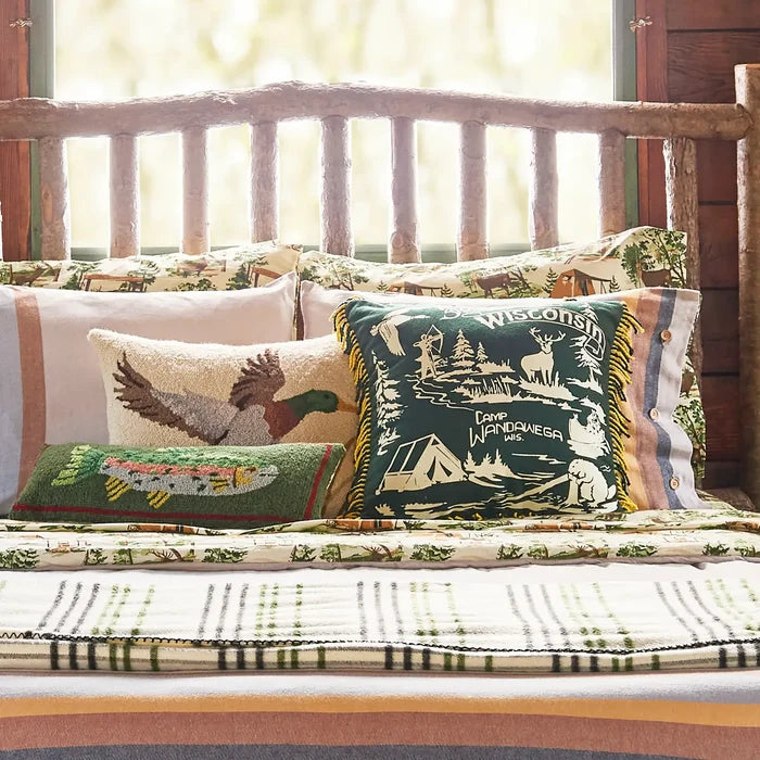 Rustic log headboard bed, plaid blanket, unique patterned pillows, Peking Camp Wandawega Trout Hook Pillow for cabin decor.