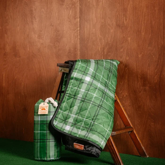 Camp Wandawega x Peking picnic blanket on ladder with carry bag, green carpet background, stylish cozy picnic essentials.