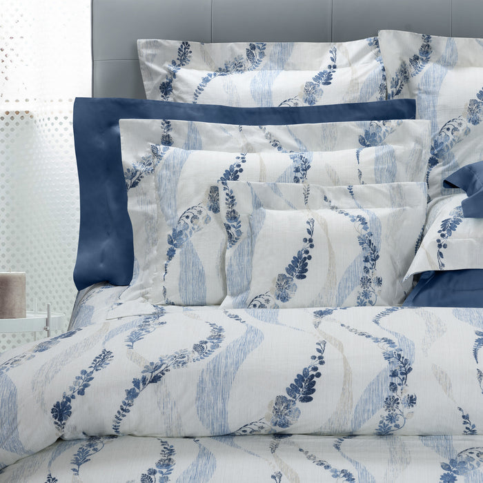 Daria pillowcase sham and duvet cover on a bed with a gray headboard.