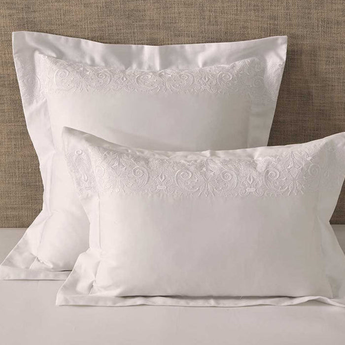Fion White Pillowcase on a bed with a beige headboard.