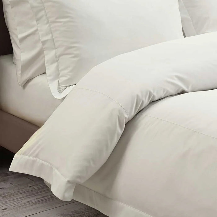Close-up of Heirloom Picot Ivory Stitch Duvet Cover Set on a wooden floor.