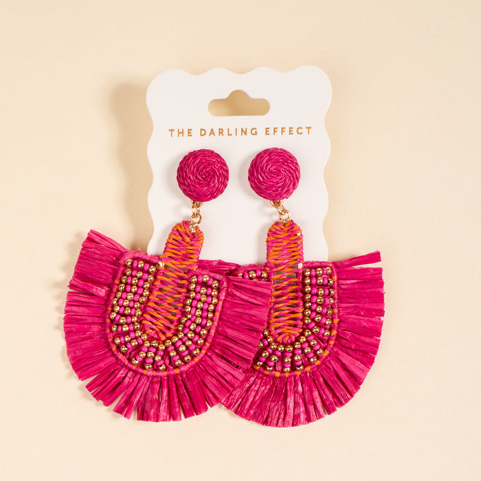 Hot Pink Fringe Earrings by The Darling Effect—these boho, fan-shaped earrings with beaded and woven details are displayed on a branded card against a light beige background. Lightweight and perfect for everyday wear.