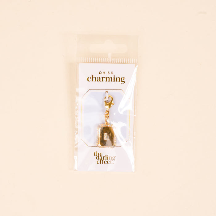 The-darling-effect L Jewelry Charm Initial Letter Gold features a gold-plated brass charm with a diamond-encrusted border and clasp, packaged in plastic with "OH SO charming" and "the darling effect."βperfect for personalized jewelry lovers.