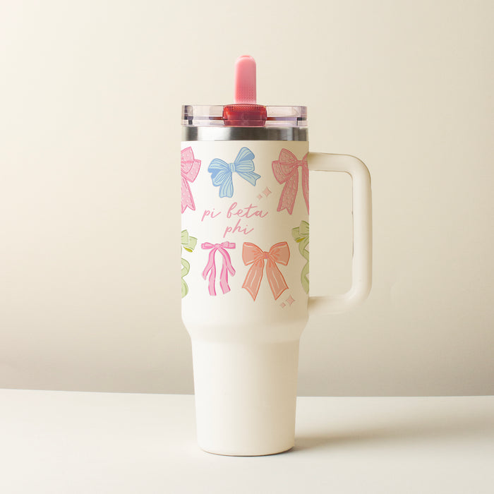 The Darling Effect's Pi Beta Phi 40 oz Lifestyle Flip Straw Tumbler Bow Affair features a white design with pastel bows, “pi beta phi” text, a handle, a clear leak-resistant lid, and a pink straw against a plain light background.