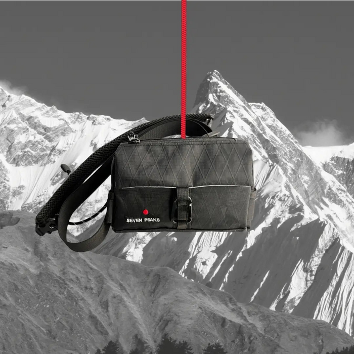 Forager Provisions LTD Seven Peaks all-black water-resistant fanny pack hanging against a mountain backdrop.