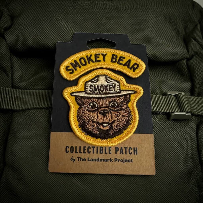 Forager Provisions LTD Smokey Bear embroidered varsity patch on a green backpack, featuring classic bear artwork.