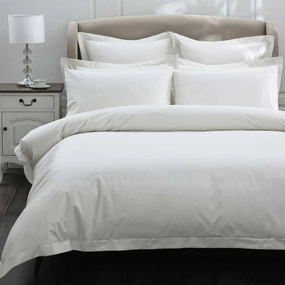 300TC Cotton Ivory Duvet Cover Set on a bed with a nightstand and lamp in the background