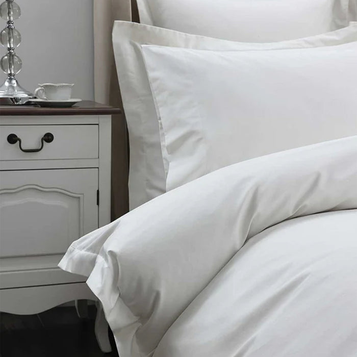 300TC Cotton Ivory Pillowcase on a bed with a nightstand in the background