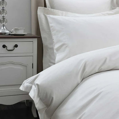 300TC Cotton Ivory Pillowcase on a bed with a nightstand in the background