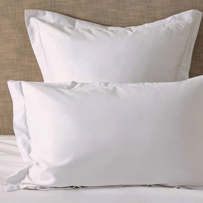500TC Egyptian Cotton White Pillowcases on a bed with a neutral headboard.