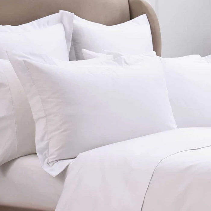 500TC Egyptian Cotton White Pillowcases on a beige bed with a neutral background