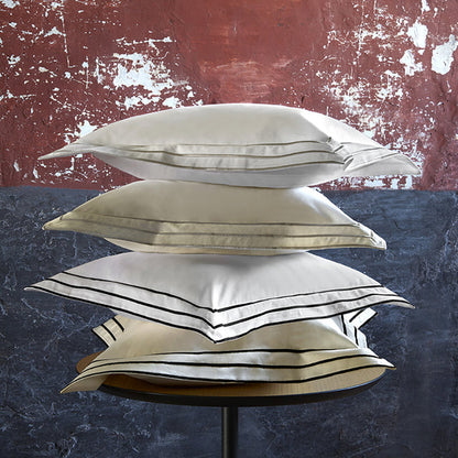 Stack of Alba white sand and black pillowcase sham on a textured background