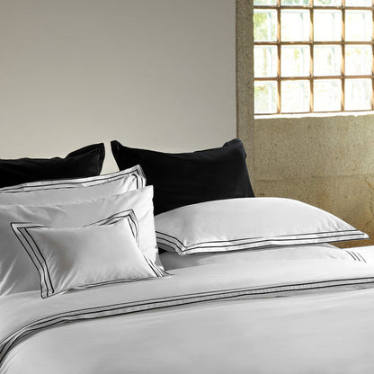 alba_white_black_sham pillowcase and duvet cover on a bed in a room with a window.