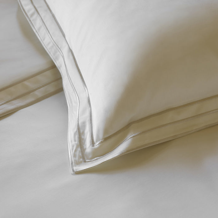Close-up of Alba white sand pillowcase sham on a bed