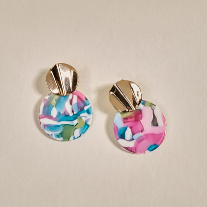 The Darling Effect's Aurora Marble Muse Earrings feature shiny gold studs and large, lightweight acetate dangles with a pink, blue, green, and white marbled pattern on a neutral background.