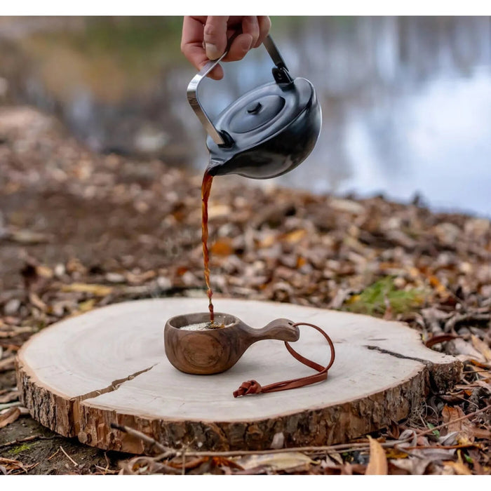Forager Provisions LTD BeaverCraft walnut kuksa cup being filled with coffee from a black kettle in a forest setting