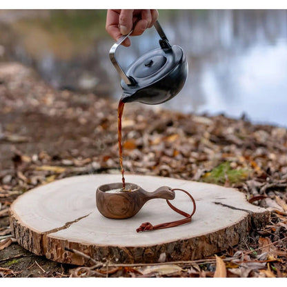 Forager Provisions LTD BeaverCraft walnut kuksa cup being filled with coffee from a black kettle in a forest setting