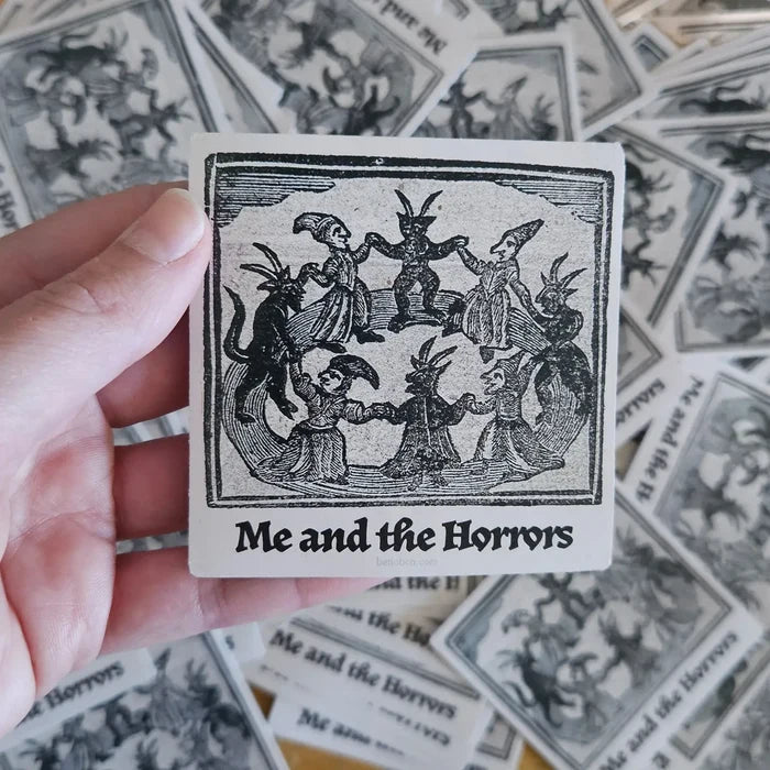 Hand holding Betiobca Vinyl Sticker—Me and the Horrors, with unique folklore dancing figures. Perfect for art sticker lovers.