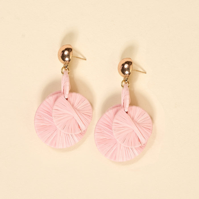 The Darling Effect's Blush Pretty and Polished Earrings are pink, circular, woven boho pieces with gold ball studs, ideal for everyday wear and shown on a light beige background.