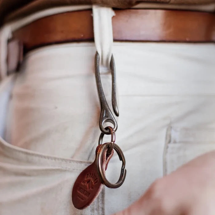 Bradley Mountain Brass Fish Hook Key Fob attached to a white pants belt loop, brown leather belt, stylish everyday carry accessory.