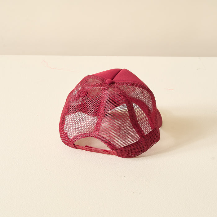The Darling Effect Burgundy Game Day Trucker Hat is shown upside down on a light surface, highlighting its mesh back and adjustable strap—ideal for displaying team spirit.