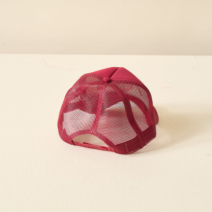 The Darling Effect Burgundy Game Day Trucker Hat is shown upside down on a light surface, highlighting its mesh back and adjustable strap—ideal for displaying team spirit.