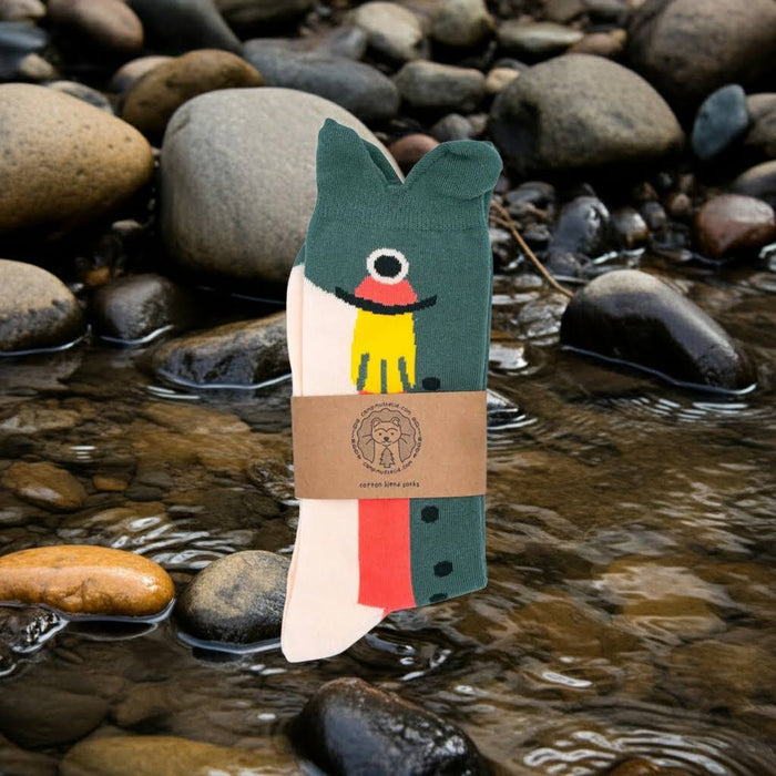 Camp Mustelid Trout Socks (Oct 2026) displayed on rocks by a clear stream, perfect for outdoor adventures and fishing trips.
