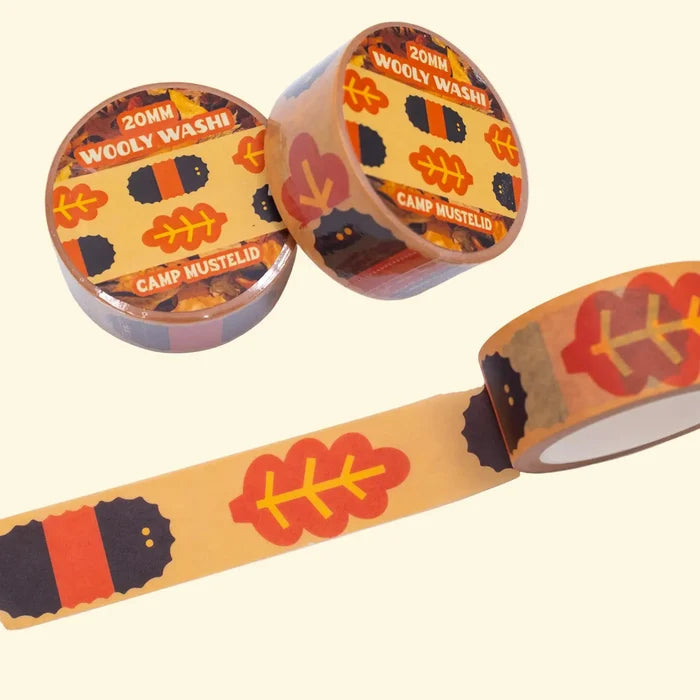 Camp Mustelid Wooly Washi Tape features vibrant red leaves and playful black-and-red animals on an eye-catching orange background.
