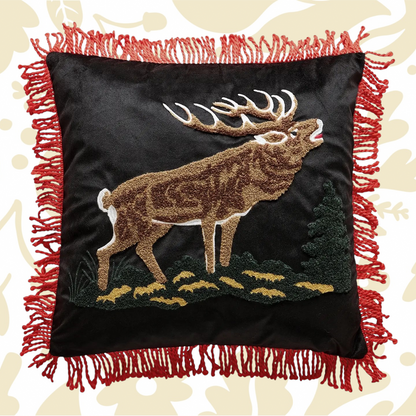 Forager Provisions LTD needle punch elk pillow on black fabric with red tassel trim and lodge-inspired design.