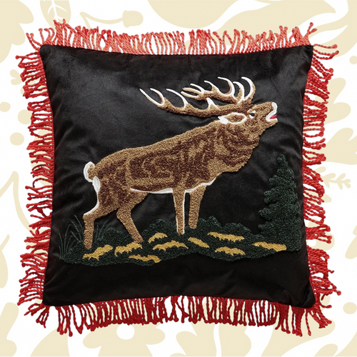 Forager Provisions LTD needle punch elk pillow on black fabric with red tassel trim and lodge-inspired design.
