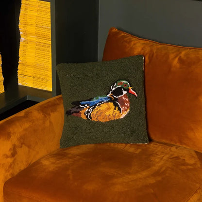 Peking Camp Wandawega Wood Duck Hook Pillow 14x14 on orange velvet chair, yellow books nearby, cozy home decor accent.