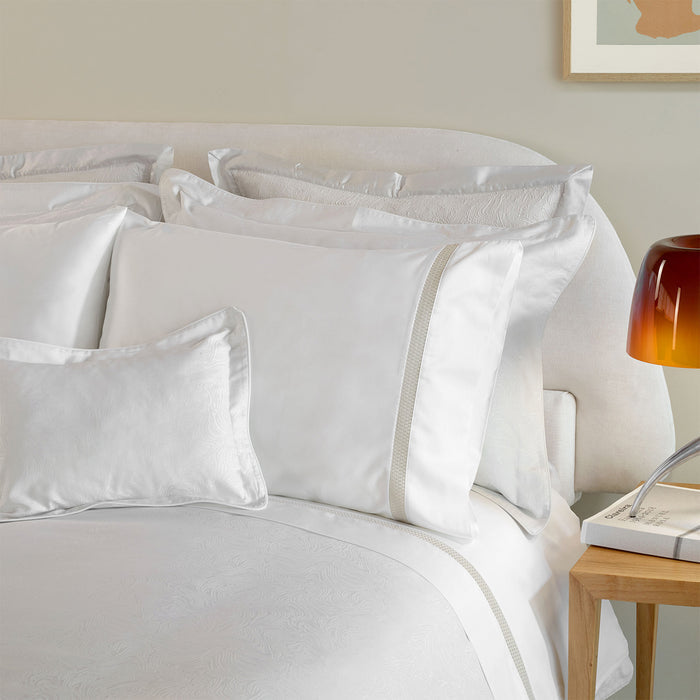 Caravela-PaleGrey duvet cover and pillowcase sham on a bed in a bedroom setting.