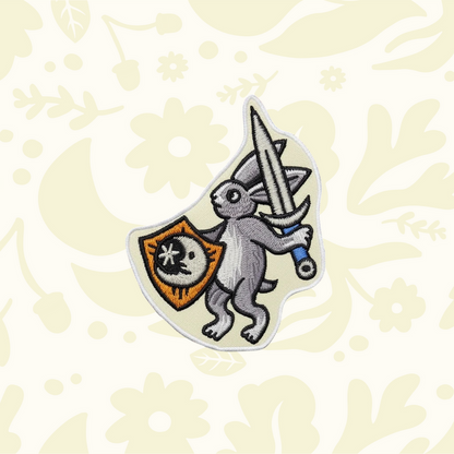 Cat Coven Medieval Warrior Rabbit Iron-On Patch featuring a rabbit with sword, shield, and floral embroidery design.