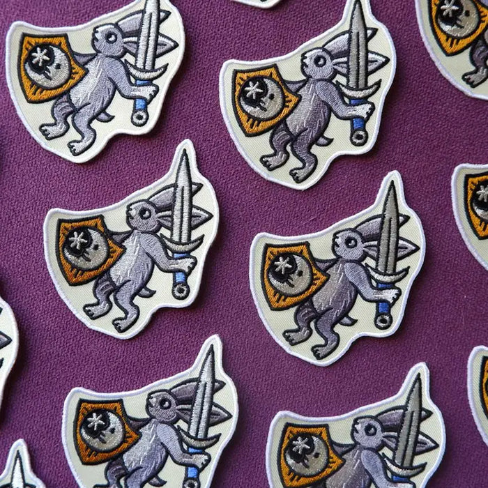 Cat Coven patch: embroidered medieval bunny with sword and shield on purple, unique gothic accessory.