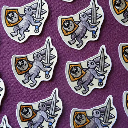 Cat Coven patch: embroidered medieval bunny with sword and shield on purple, unique gothic accessory.
