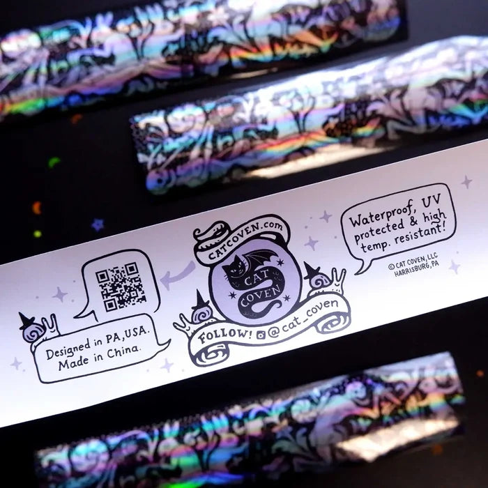 Cat Coven label with QR code and details beside a Cat Coven Rabbits vs Skeletons holographic sticker. Unique gothic merch.