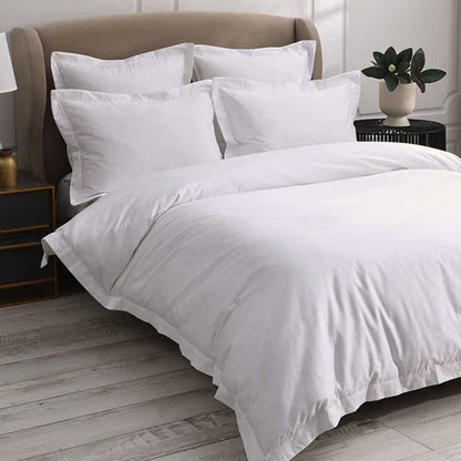 Cavendish White Duvet Cover Set on a bed in a bedroom with a plant and nightstands.