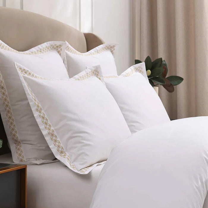 Cavendish Gold Pillowcase on a beige sofa in a room with curtains and a plant.