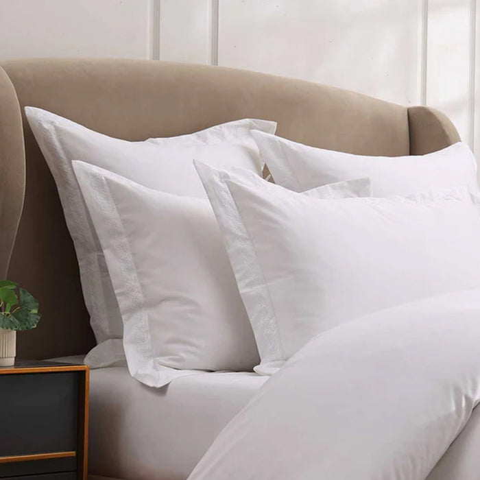 Cavendish White Pillowcase on a bed with a neutral headboard and nightstand.
