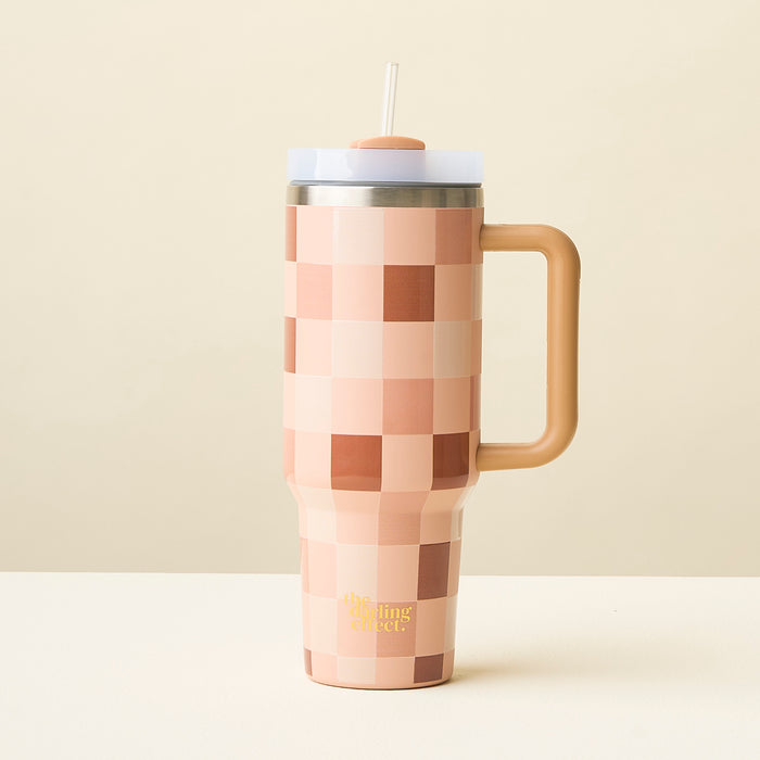 The Darling Effect's Check Brown 40 oz Take Me Everywhere Tumbler features a handle, straw, and checkered peach/beige print with custom branding near the bottom, shown on a light surface against a plain beige background.