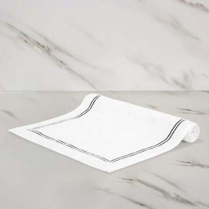 folded side of of a white grey classic bath mat on a marbeled surface and background