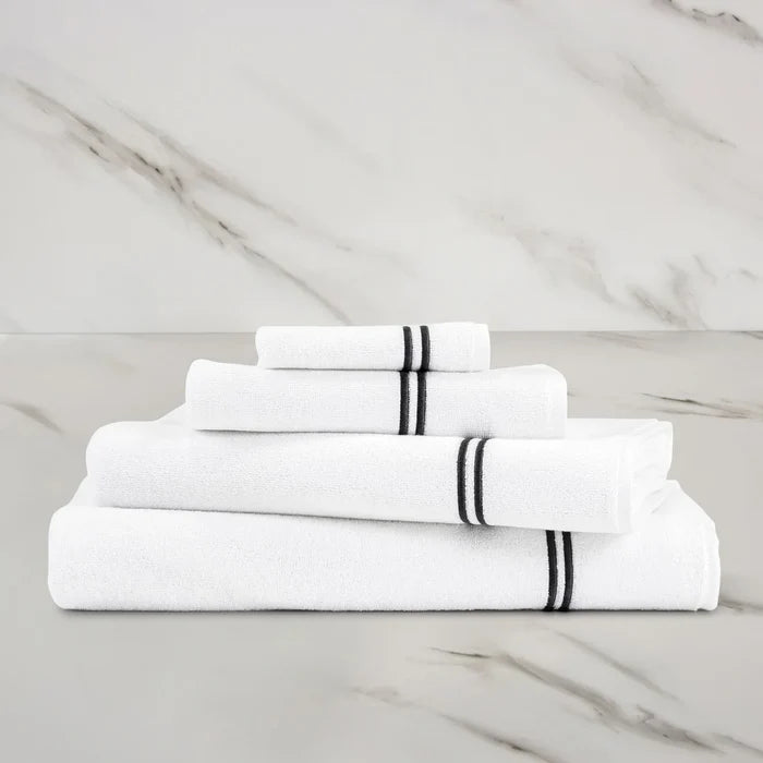 a white grey Classic Bath towel with other Classic towels stacked on on a marbeled surface and background