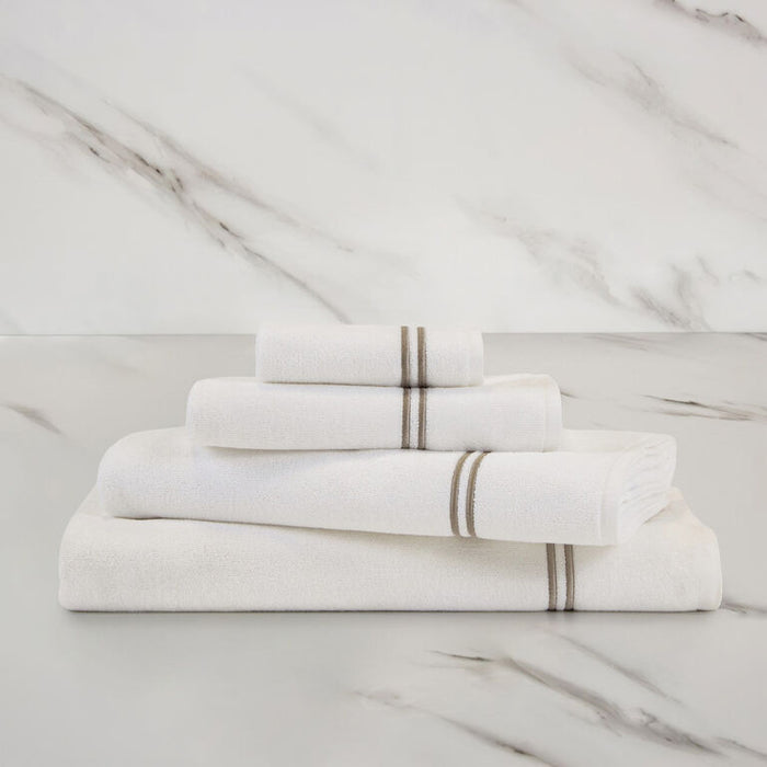 a white khaki Classic Bath towel with other Classic towels stacked on in on a marbeled surface and background