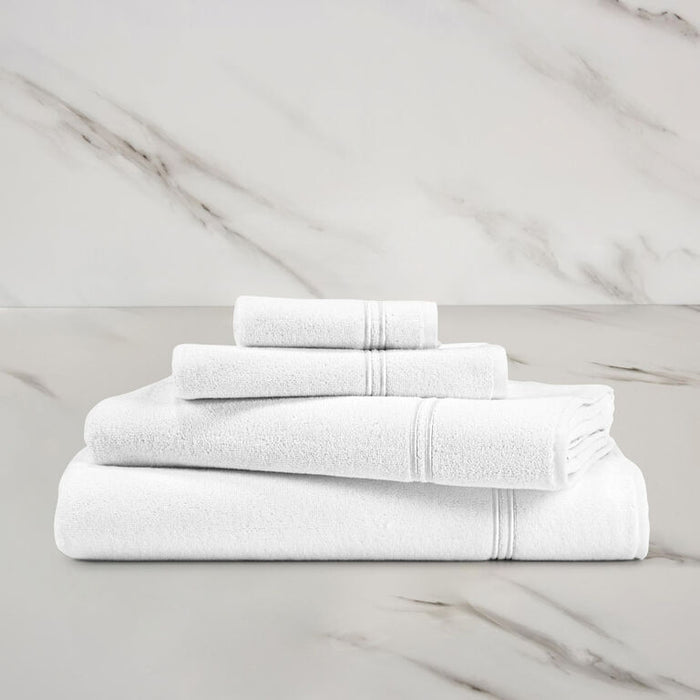 a white white Classic Bath towel with other Classic towels stacked on in on a marbeled surface and background
