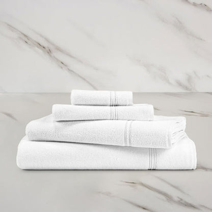 a white white Classic Bath towel with other Classic towels stacked on in on a marbeled surface and background