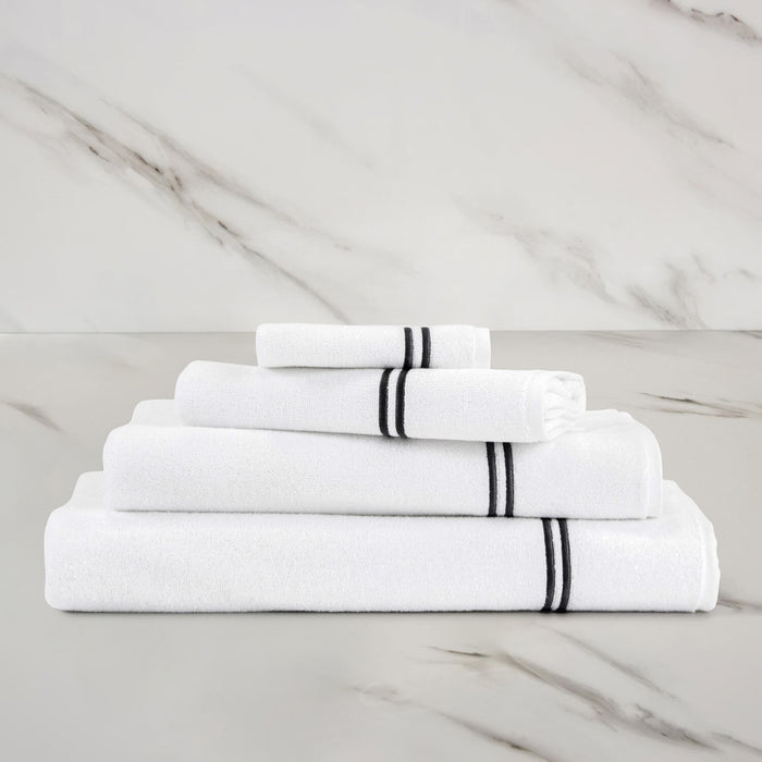 folded white grey classic guest towel stacked on other classic towels on a marbeled surface and background