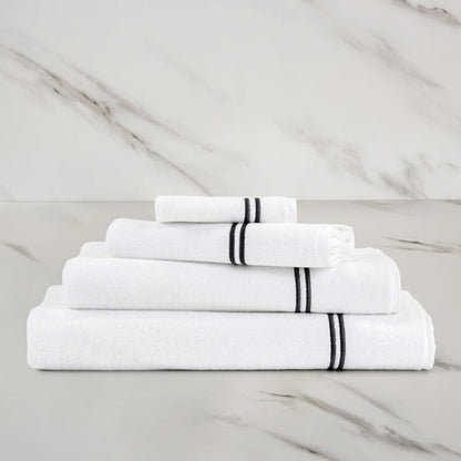 folded white grey classic guest towel stacked on other classic towels on a marbeled surface and background