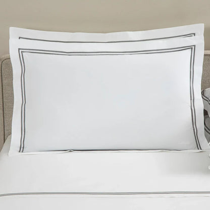 front view of classic pillowcase sham white grey on a bed