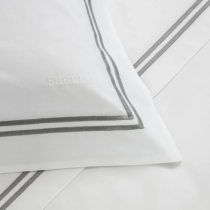 close up of the fabric details of the classic white - grey pillowcase sham