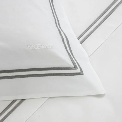 close up of the fabric details of the classic white - grey pillowcase sham